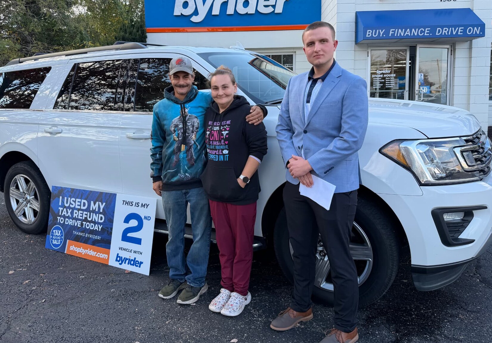 Byrider customers with their salesperson and their Ford Expedition during the Tax Refund Sale at a Byrider store in Ohio