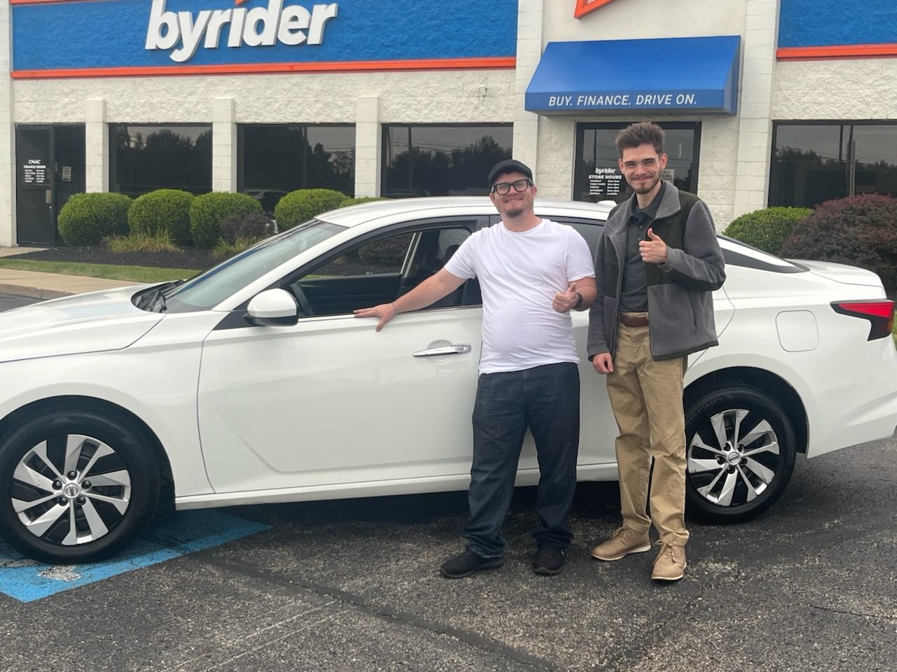 Byrider Mansfield customer and salesperson beside their used Nissan Sentra at the Mansfield, Ohio dealership