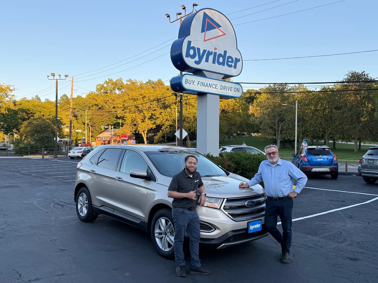 Byrider Euclid customer and salesperson beside their used Ford Edge at the Euclid, Ohio dealership