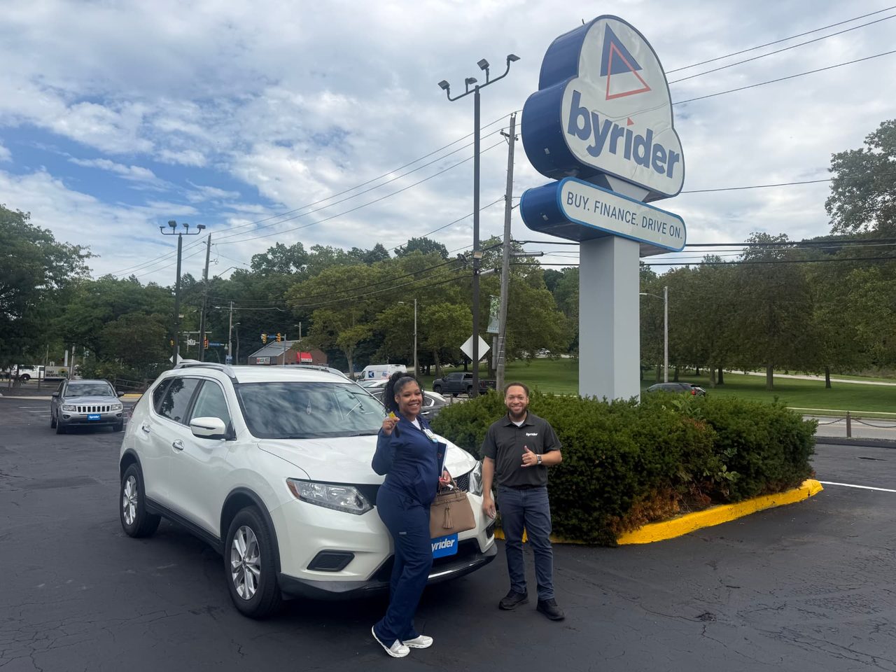 Byrider Euclid customer and salesperson beside their used Nissan Rogue at the Euclid, Ohio dealership
