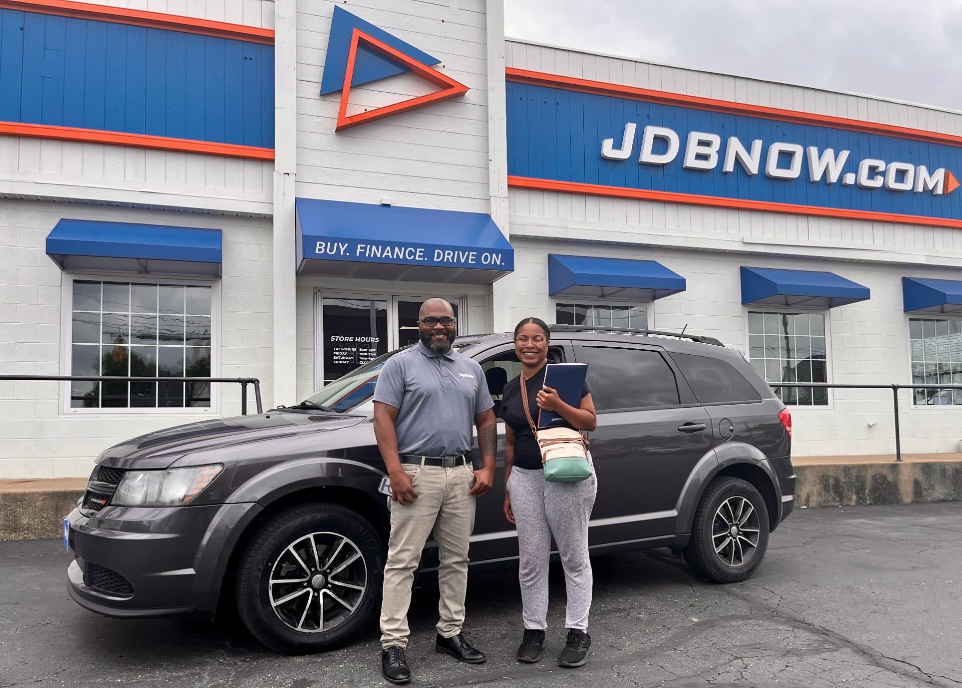 Byrider Canton salesperson and customer beside their used Dodge Journey at the Canton, Ohio dealership