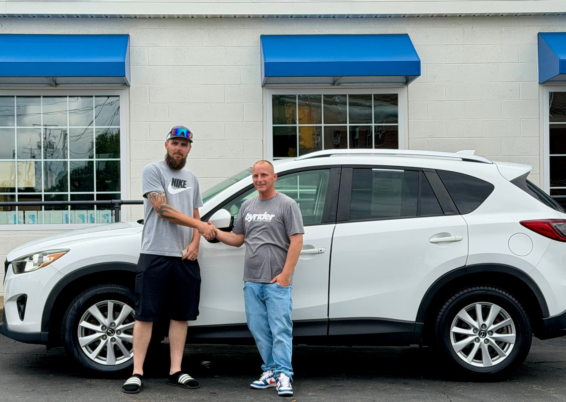 Byrider Canton customer and salesperson beside their used Mazda CX-5 at the Canton, Ohio dealership