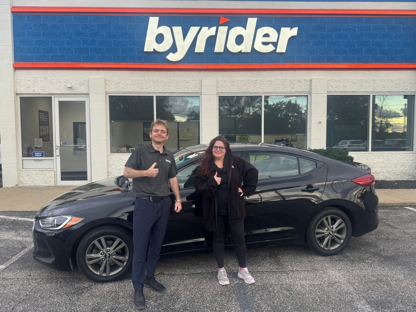 Byrider Ashtabula customer and salesperson beside their used Hyundai Elantra at the Ashtabula, Ohio dealership