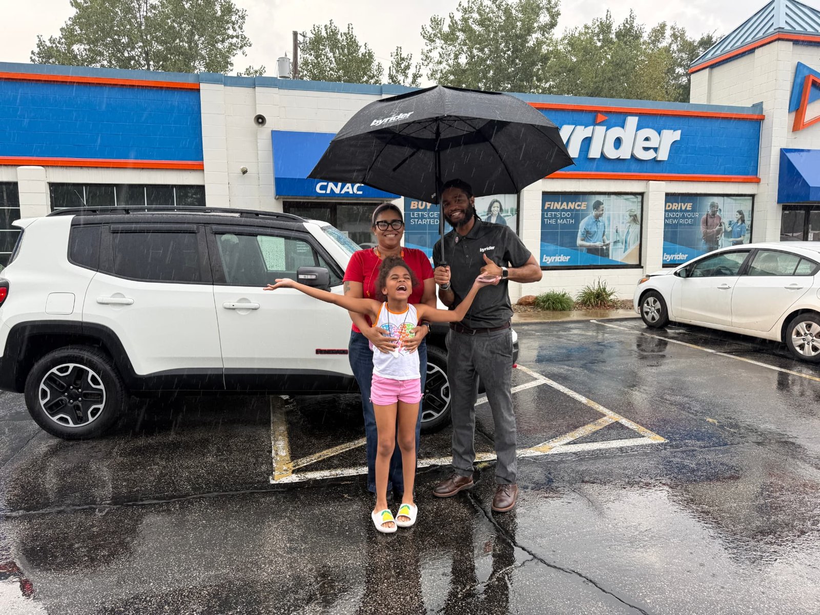 Byrider Amherst customers and salesperson with their used Jeep Renegade at the Amherst, Ohio dealership