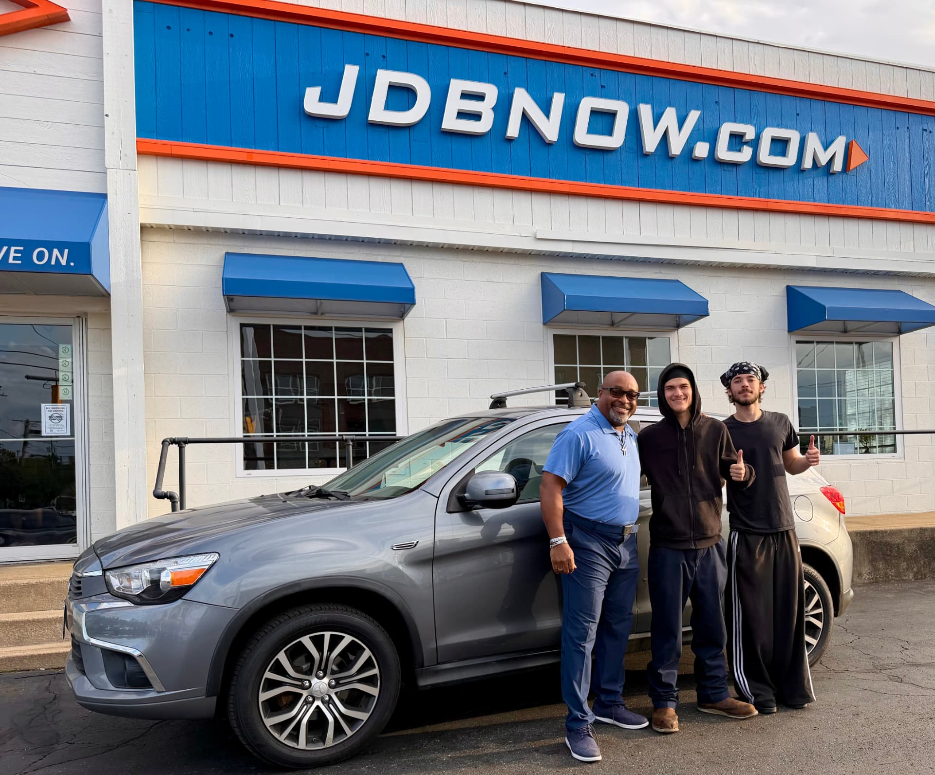 Byrider Canton salesperson and two customers with their used Mitsubishi Outlander at the Canton, Ohio dealership