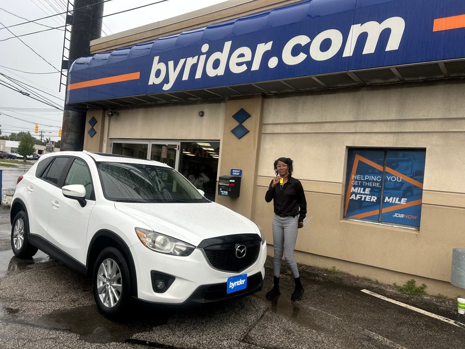 Byrider Cleveland customer and salesperson beside their used Mazda CX-5 at the Cleveland, Ohio dealership