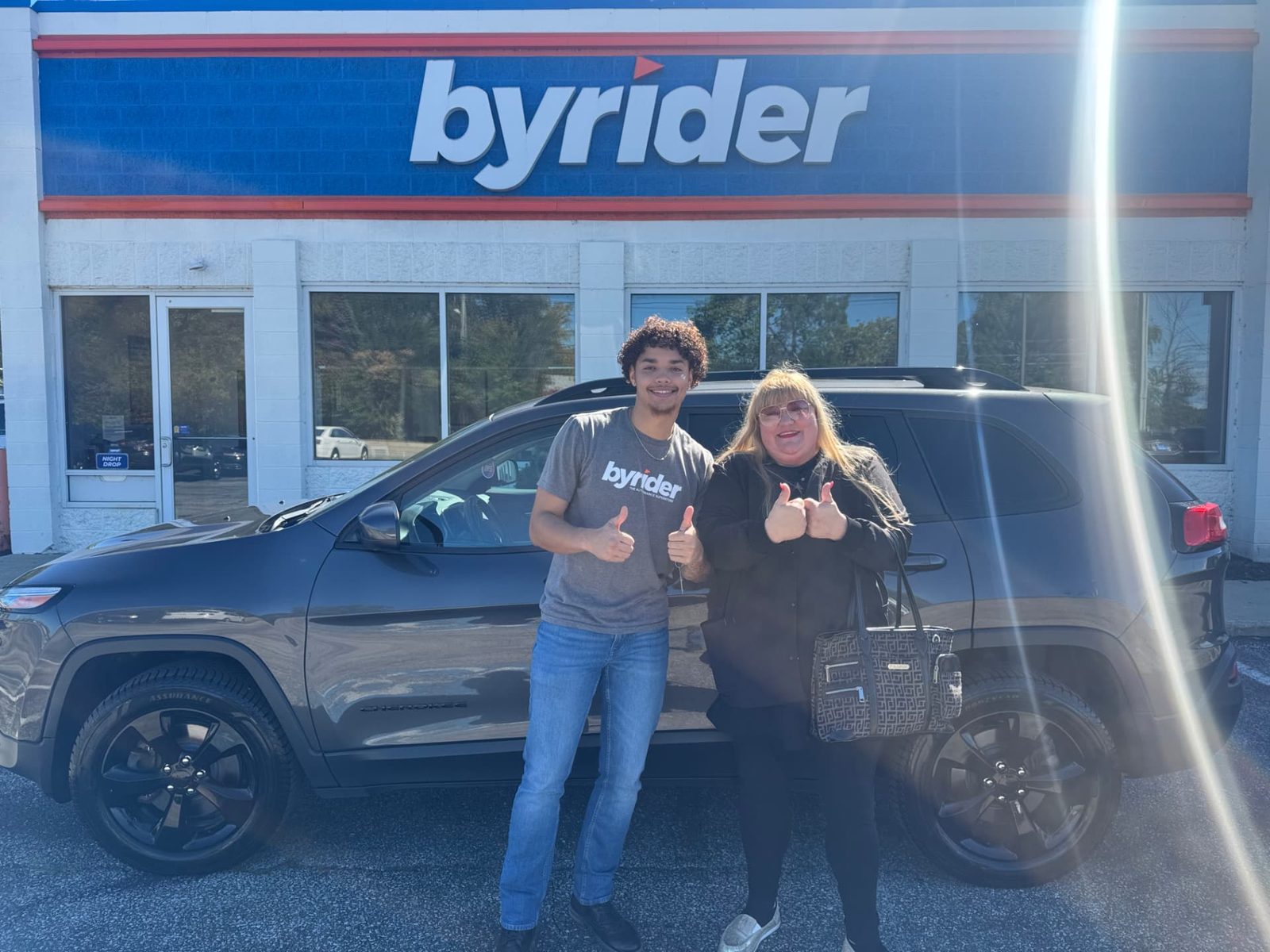 Byrider Ashtabula customer and salesperson beside their used Jeep Cherokee at the Ashtabula, Ohio dealership