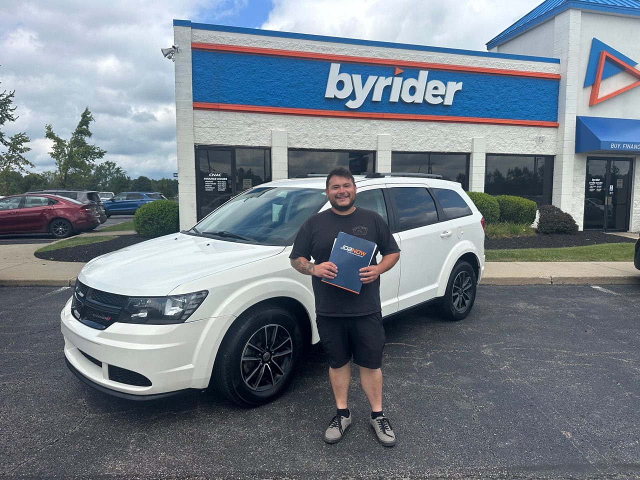 Byrider Mansfield customer and salesperson beside their used Dodge Journey at the Mansfield, Ohio dealership