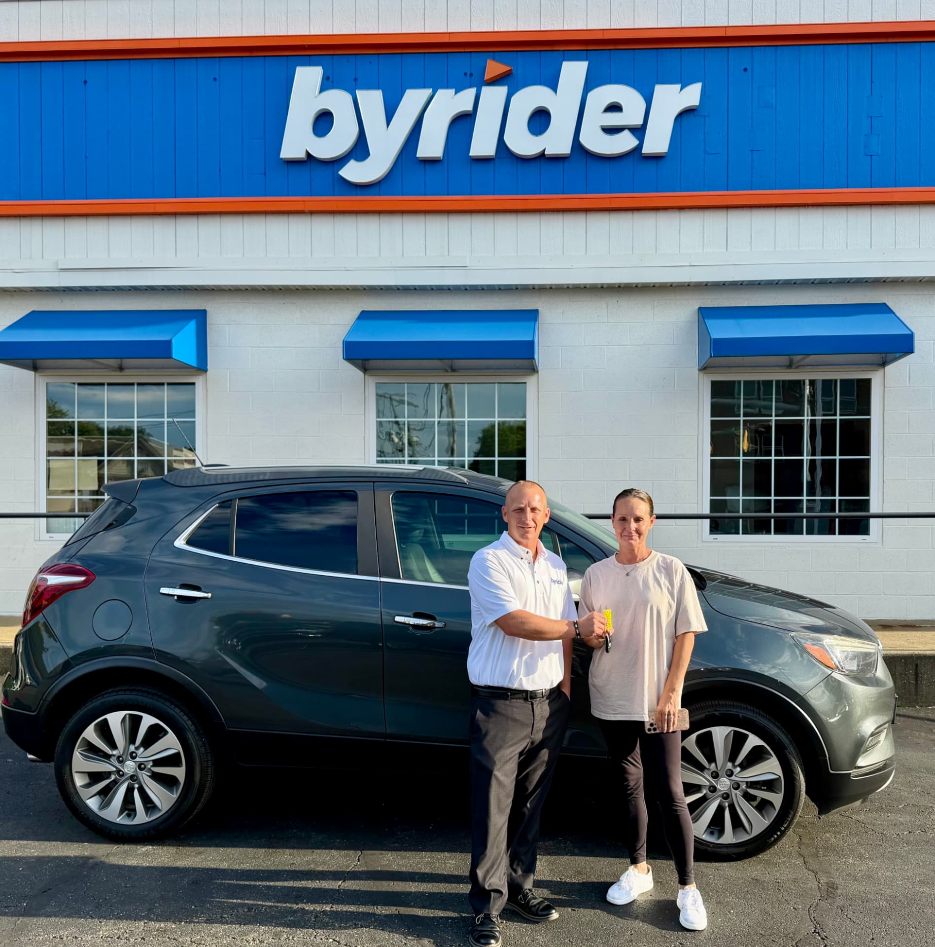 Byrider Canton salesperson and customer beside their used Buick Encore at the Canton, Ohio dealership
